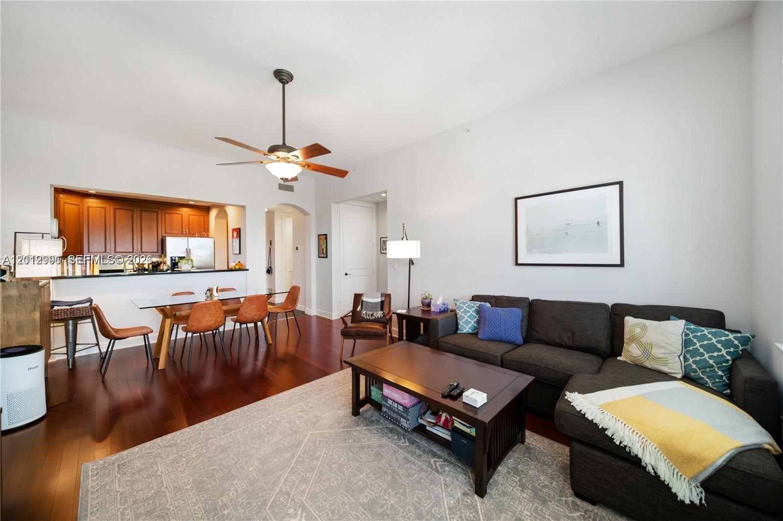 A living room with a dark sectional sofa, coffee table, and adjacent dining area — 200 NE 2nd Ave # 304, Delray Beach FL 33444, DELRAY BEACH, FL