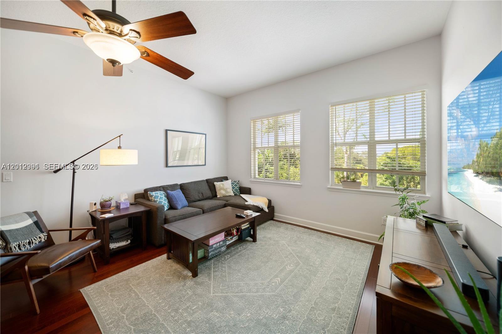 A living room features a sectional sofa, area rug, ceiling fan, and two large windows — 200 NE 2nd Ave # 304, Delray Beach FL 33444, DELRAY BEACH, FL