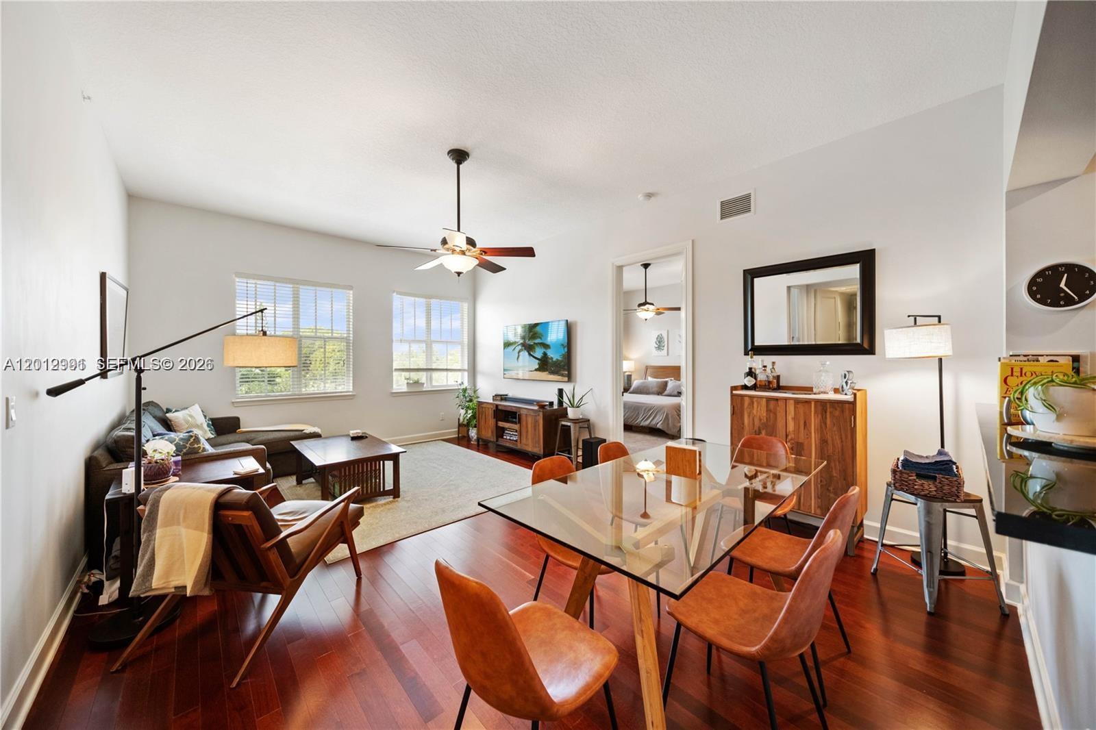 A living and dining area with hardwood floors, a glass table, and a sectional sofa — 200 NE 2nd Ave # 304, Delray Beach FL 33444, DELRAY BEACH, FL