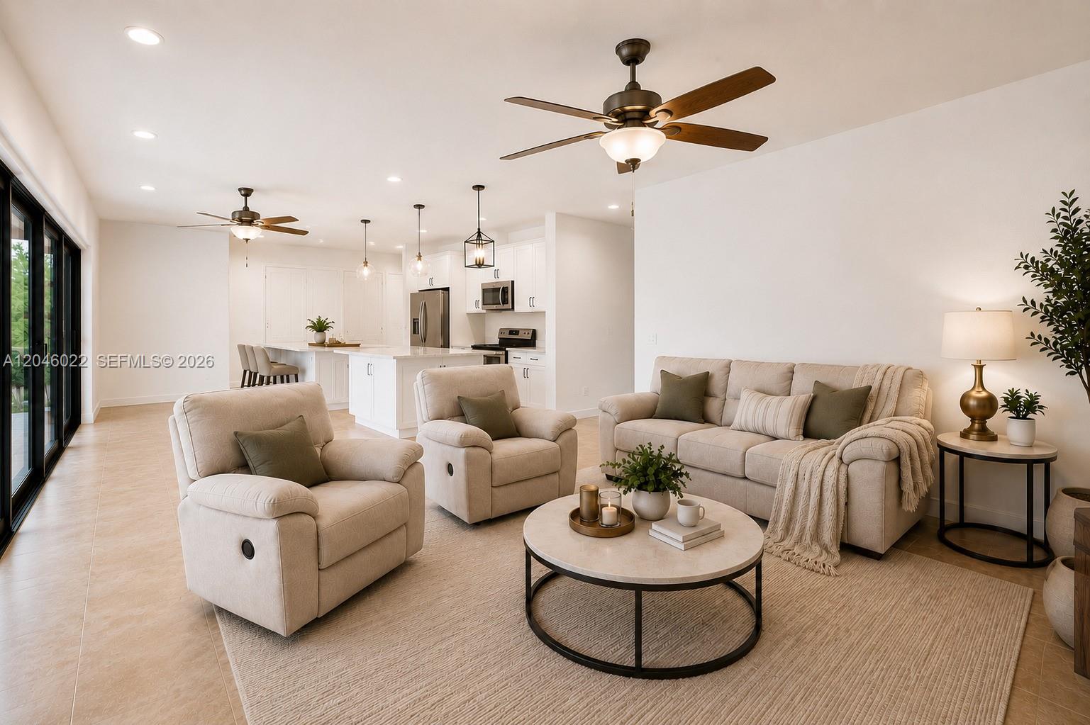 A living room with beige furniture and a ceiling fan opens to a white kitchen — 26363 SW 152nd Ave, Homestead FL 33032, HOMESTEAD, FL