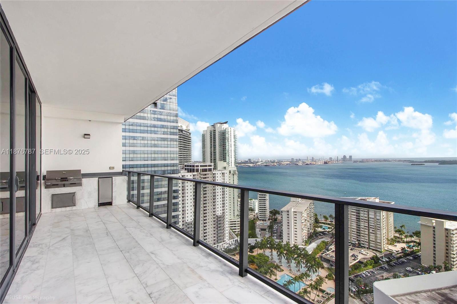 A high-rise balcony features marble flooring, a built-in grill, and panoramic waterfront city views — 1451 Brickell Ave # 3102, Miami FL 33131, MIAMI, FL