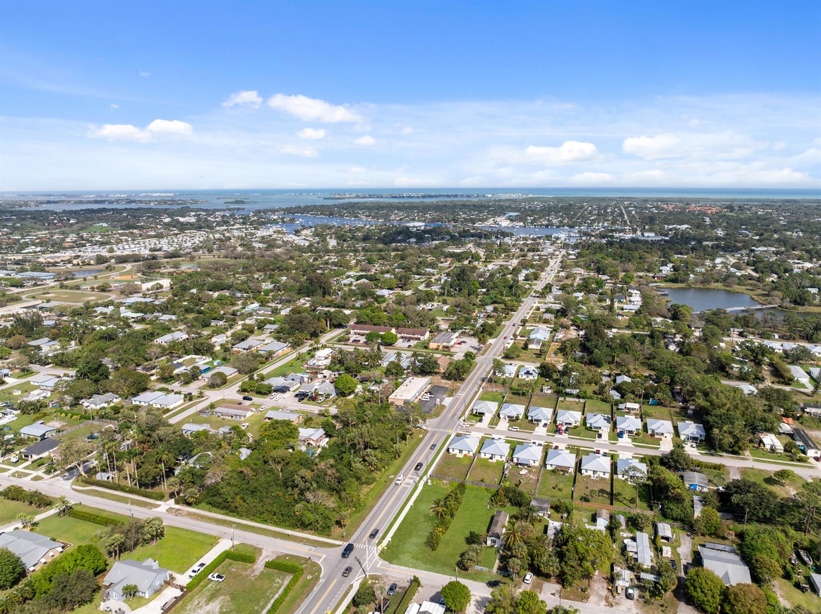 An aerial view shows a residential neighborhood with houses, streets, and a distant coastline — 5161 SE Kingfish Avenue, Stuart FL 34997, STUART, FL