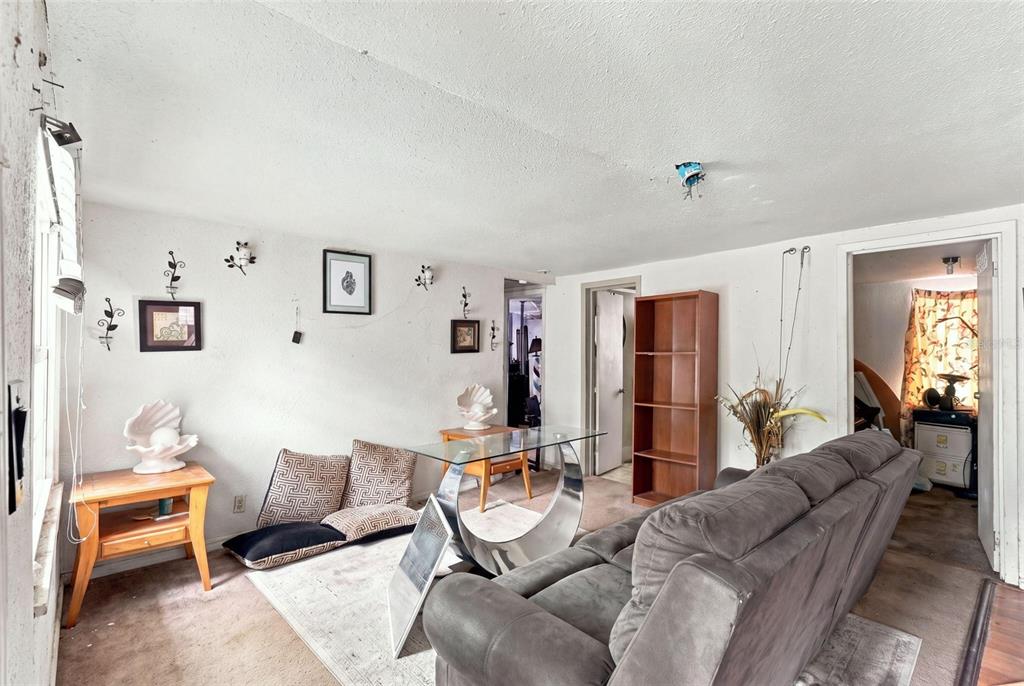 A living room features a grey sofa, a glass-topped table, and a wooden bookshelf — 2221 GRANBY STREET, SANFORD, FL