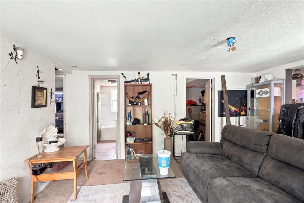 A living room features a gray sofa, a glass coffee table, and a wooden bookshelf — 2221 GRANBY STREET, SANFORD, FL