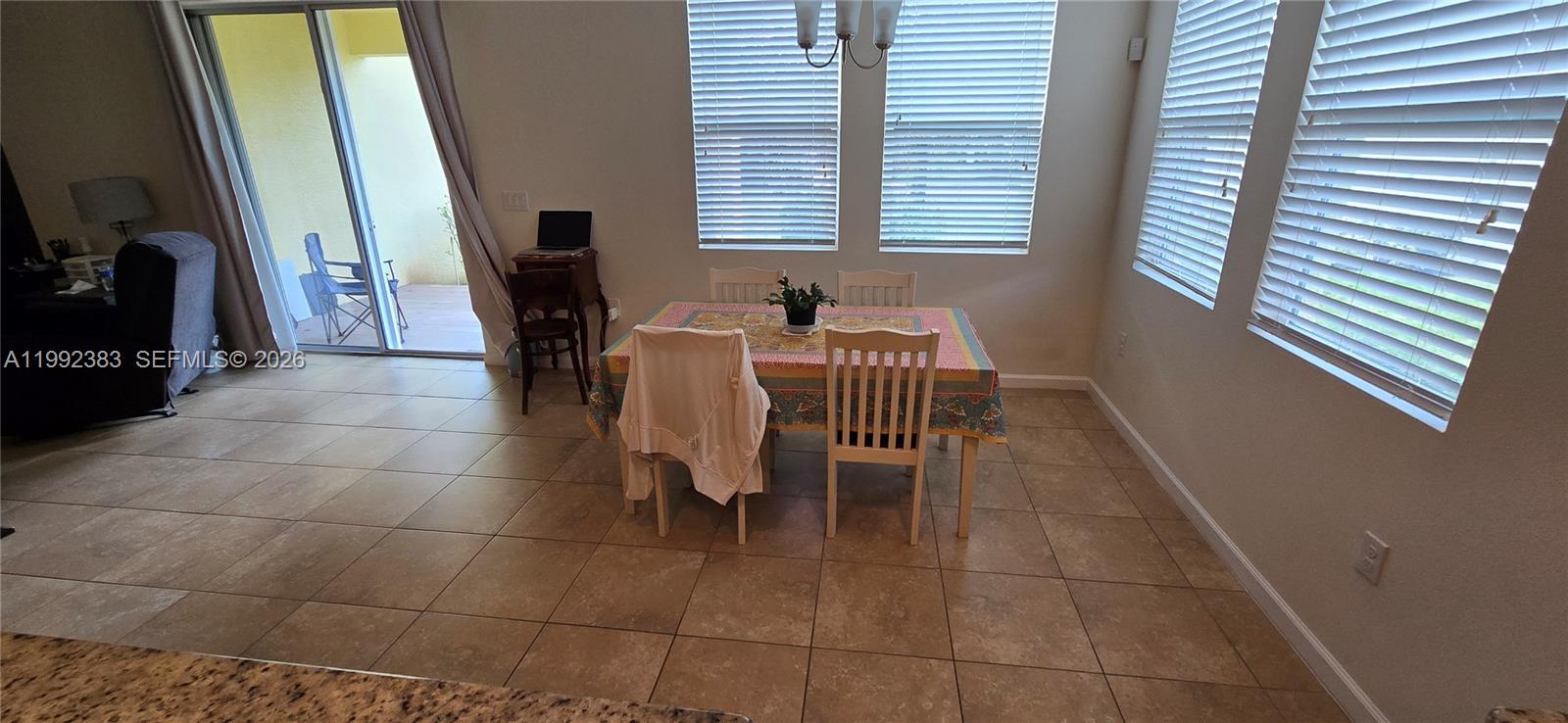 A dining area features a table with chairs, tile flooring, and windows with blinds — 1460 Caddy Ct, Vero Beach FL 32966, VERO BEACH, FL