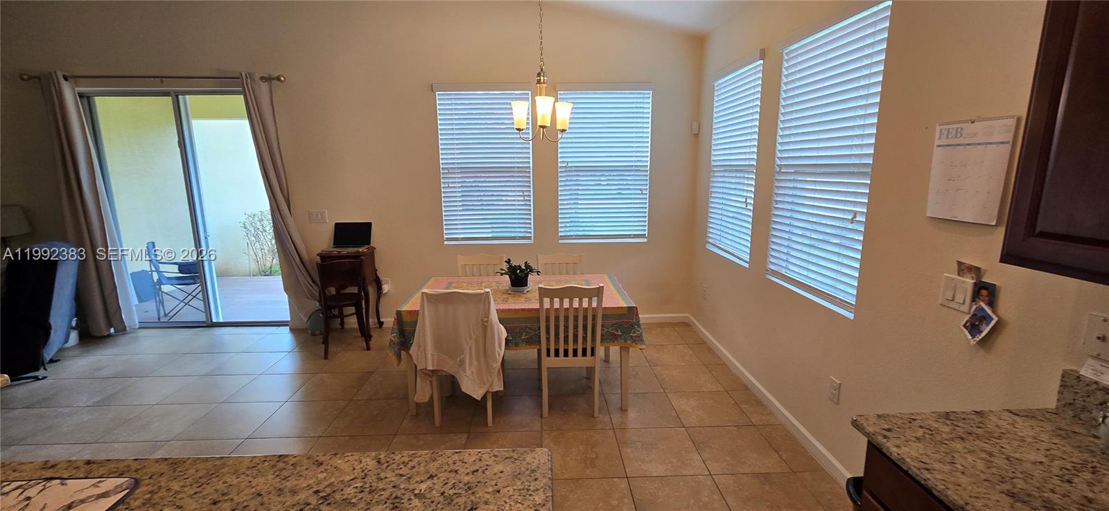 A dining area with tile floors, a table, chairs, and windows overlooking a patio — 1460 Caddy Ct, Vero Beach FL 32966, VERO BEACH, FL
