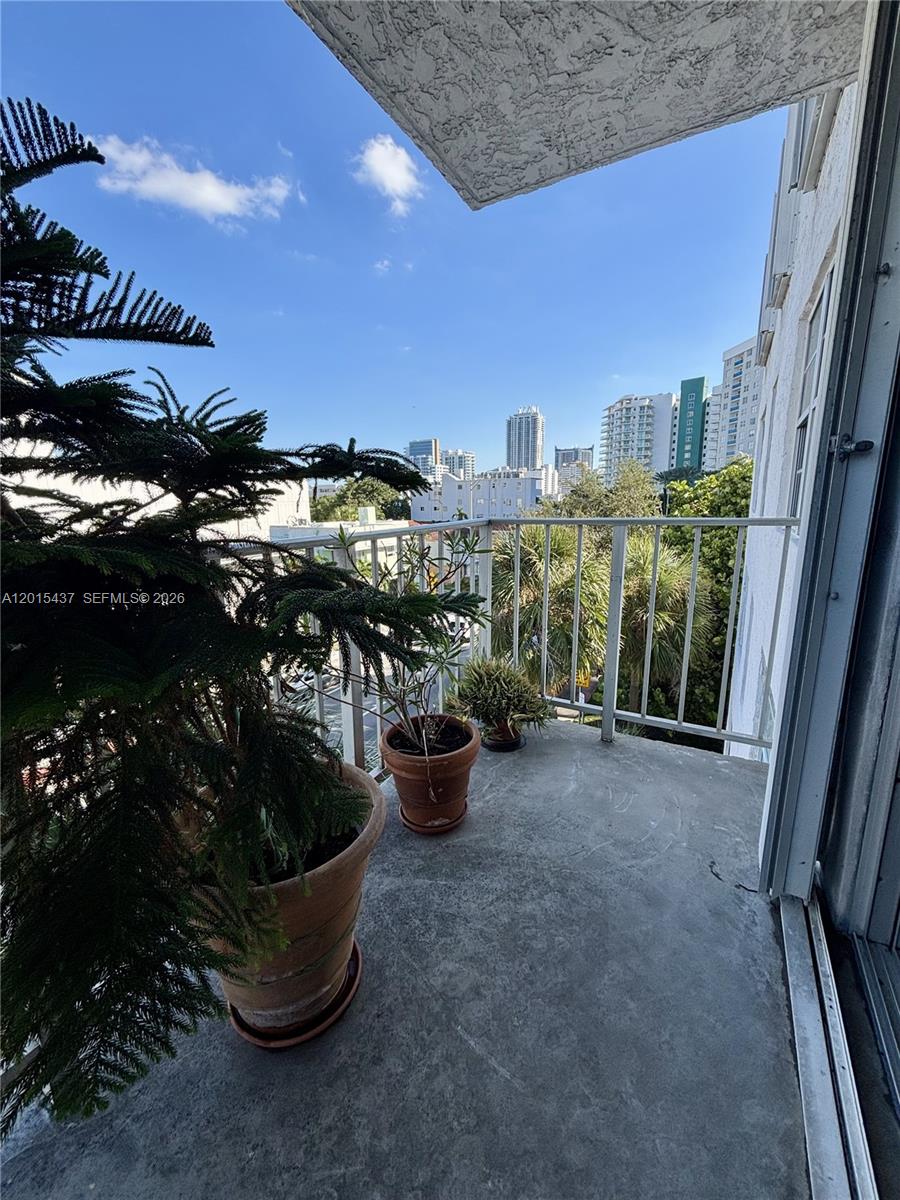 A balcony with potted plants overlooks a city skyline under a clear blue sky — 6801 Indian Creek Dr # 402, Miami Beach FL 33141, MIAMI BEACH, FL