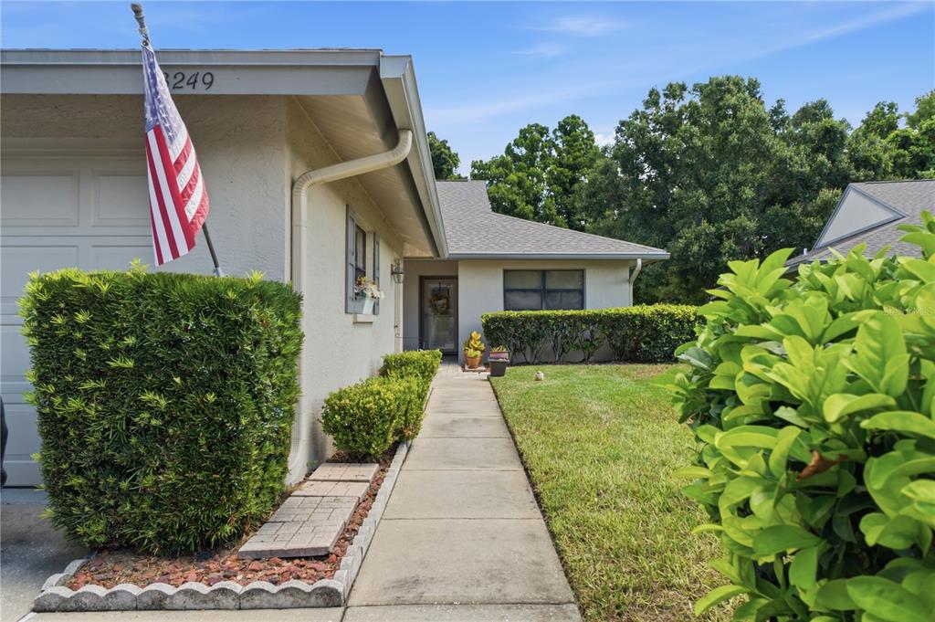 A concrete walkway leads to the front entrance of a house with a garage — 3249 LORI LANE UNIT 3249, NEW PORT RICHEY, FL