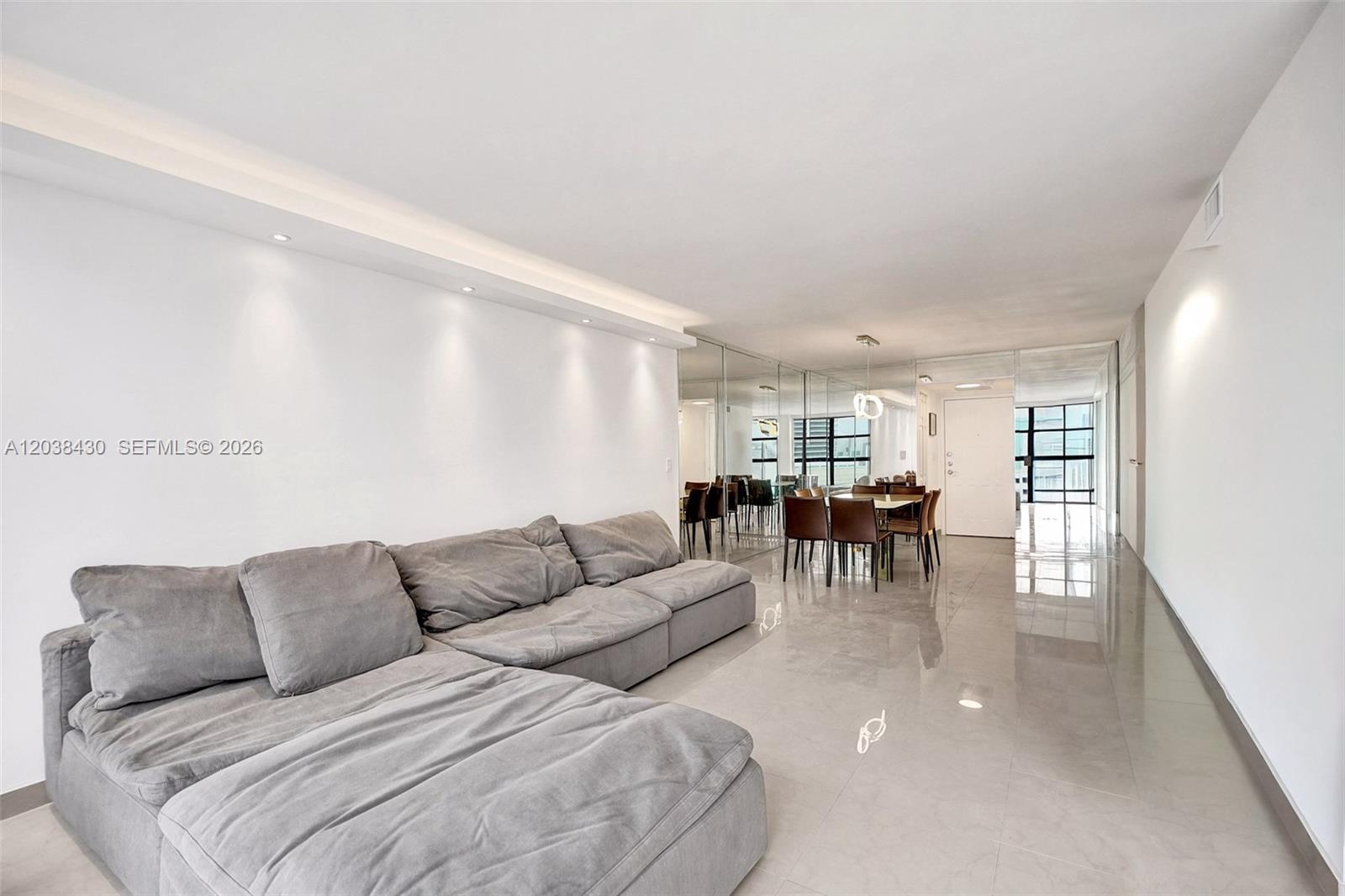 A living and dining area features white walls, recessed lighting, a grey sectional, and tile flooring — 400 Leslie Dr # 1022, Hallandale Beach FL 33009, HALLANDALE BEACH, FL
