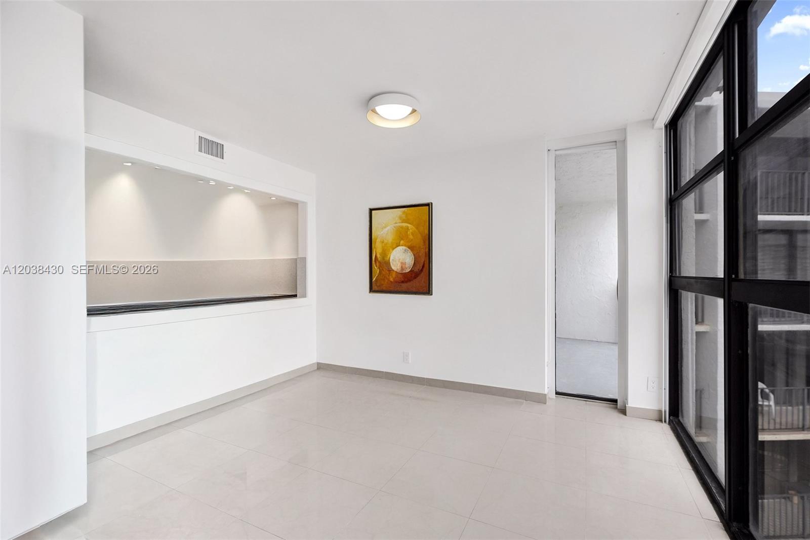A minimalist room features white walls, tile flooring, a recessed bar area, and balcony access — 400 Leslie Dr # 1022, Hallandale Beach FL 33009, HALLANDALE BEACH, FL