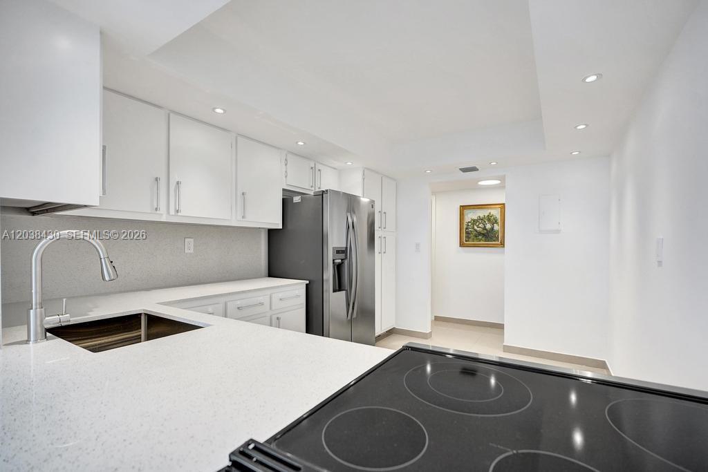 A modern kitchen features white cabinetry, stainless steel appliances, and a white quartz countertop — 400 Leslie Dr # 1022, Hallandale Beach FL 33009, HALLANDALE BEACH, FL