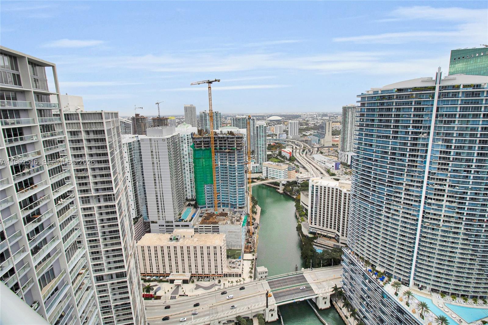 An elevated view of a city skyline featuring high-rise buildings, a river, and construction cranes — 465 Brickell Ave # 5102, Miami FL 33131, MIAMI, FL
