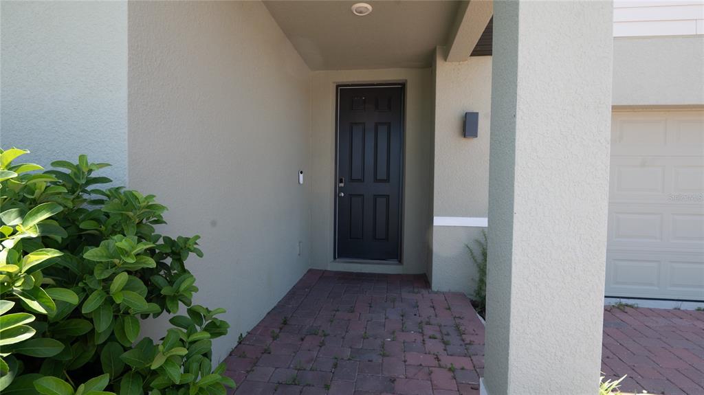 A front entrance features a dark door, a paved walkway, and a small shrub — 3198 VICEROY COURT, POINCIANA, FL
