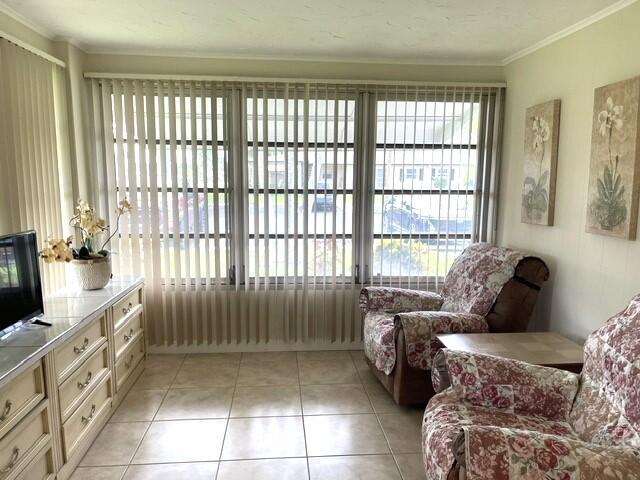 A sunroom features tile flooring, vertical blinds covering large windows, and two floral-patterned armchairs — 1152 Circle Drive # D, Delray Beach FL 33445, DELRAY BEACH, FL