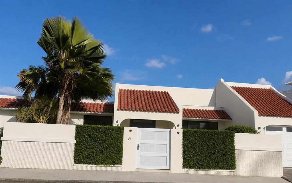 A white stucco house with a red tile roof and a gated courtyard entrance — 5 HISTELA, PUNTA LAS MARIAS, SAN JUAN, PR