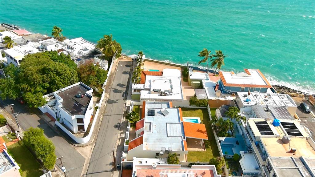 A swimming pool sits in front of a covered patio and a white house exterior — 5 HISTELA, PUNTA LAS MARIAS, SAN JUAN, PR