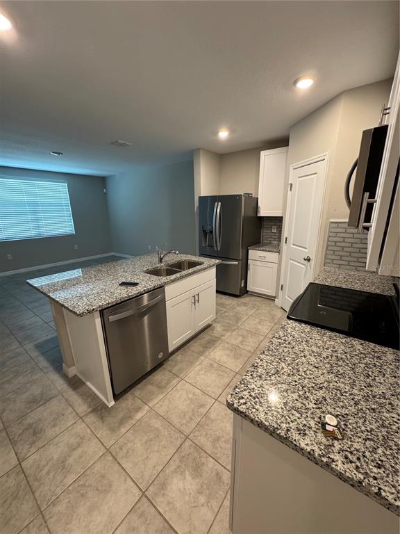 A kitchen with granite countertops, white cabinets, stainless steel appliances, and tile flooring — 5860 OCEAN ISLE DRIVE, NOKOMIS, FL