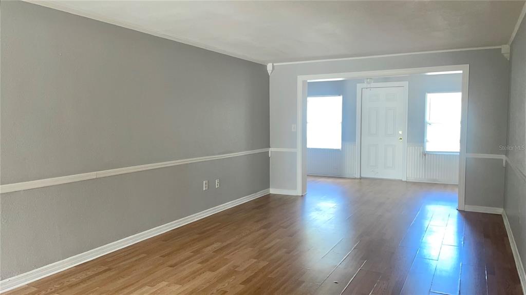 A living room with gray walls, white chair rail molding, and wood-look flooring — 4211 SHELDON PLACE UNIT 4211, NEW PORT RICHEY, FL