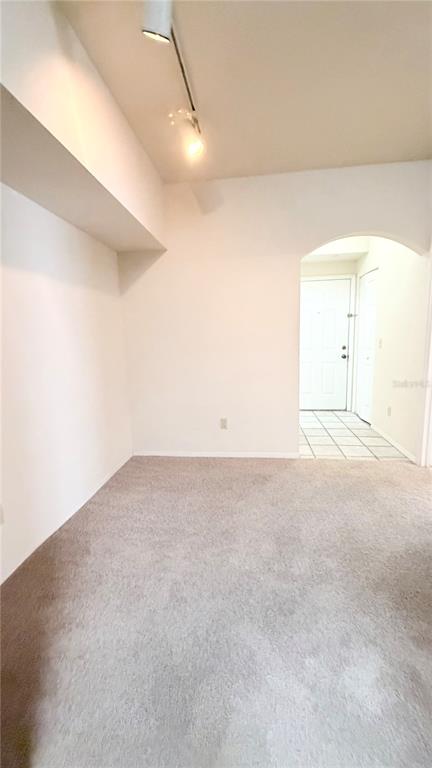 A carpeted room features a white arched doorway leading to a tiled entryway — 832 CAMARGO WAY UNIT 307, ALTAMONTE SPRINGS, FL