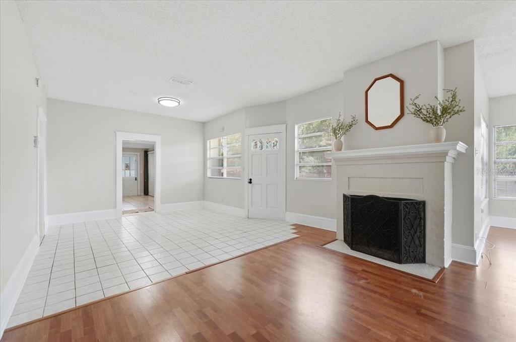 A living room features a fireplace, white tile and wood flooring, and a front door — 1950 RICHMOND ROAD, LAKELAND, FL