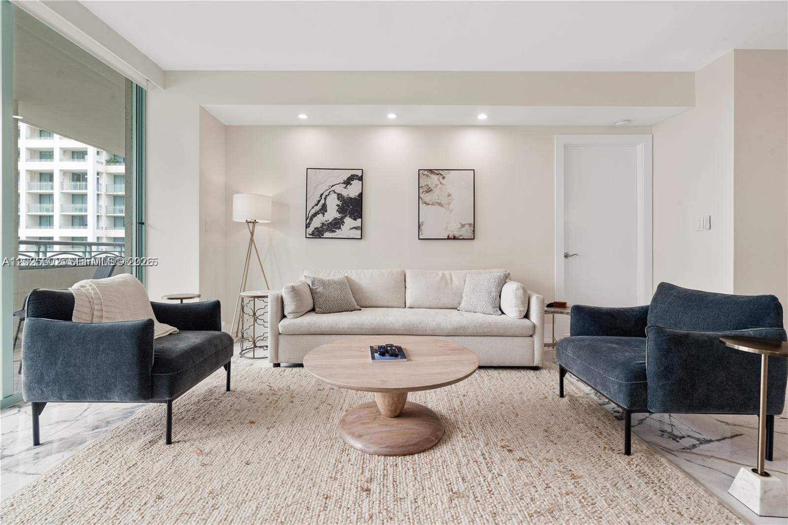 A living room features a beige sofa, two dark blue armchairs, and a round wooden table — 3400 SW 27th Ave # 605, Miami FL 33133, MIAMI, FL