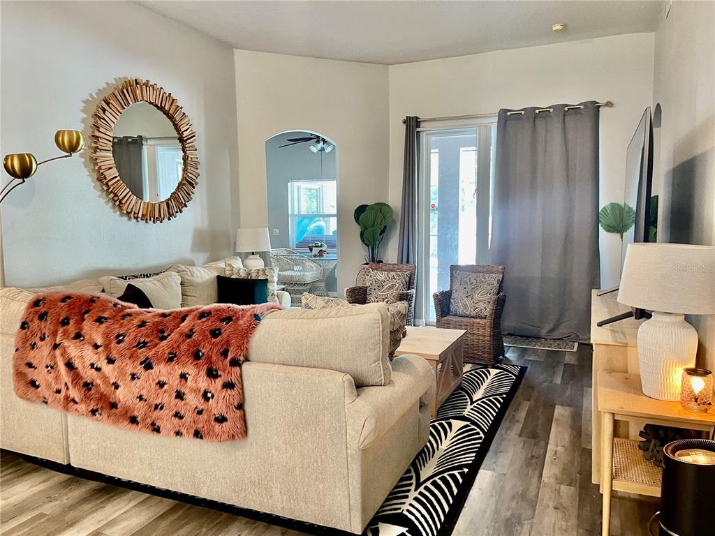 A living room features a beige sectional sofa, a patterned rug, and a circular mirror — 4314 BIEL COURT, KISSIMMEE, FL
