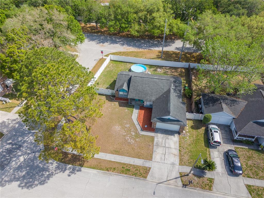 An aerial view shows a single-story house with a driveway, yard, and above-ground pool — 7532 TURTLEBROOK LANE, NEW PORT RICHEY, FL