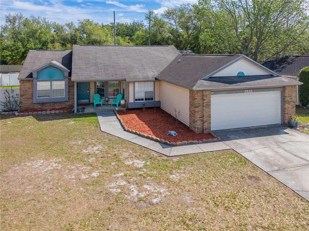 A single-story house with a brick and siding exterior, a two-car garage, and a front porch — 7532 TURTLEBROOK LANE, NEW PORT RICHEY, FL