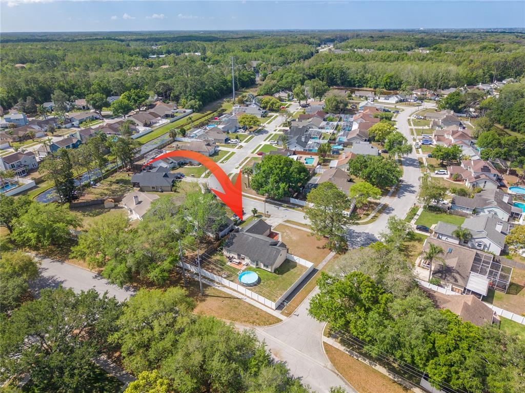 An aerial view shows a suburban house with a backyard pool and a white fence — 7532 TURTLEBROOK LANE, NEW PORT RICHEY, FL
