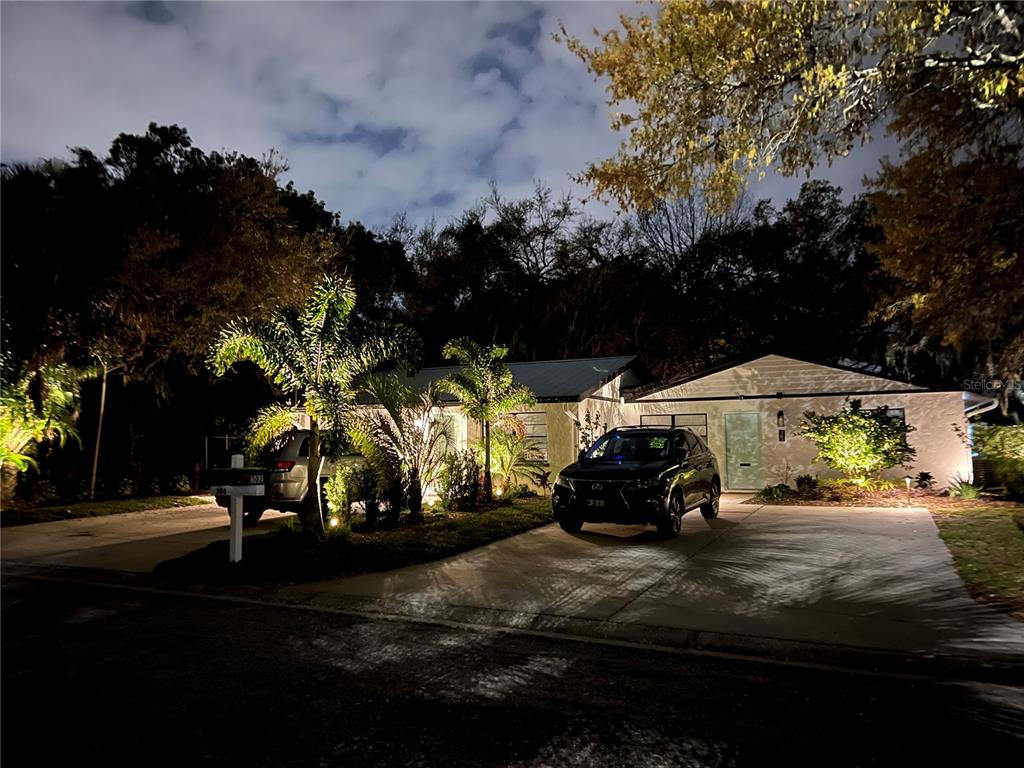 A single-story house at night with two cars parked in the concrete driveway — 302 19TH ST. EAST, BRADENTON, FL