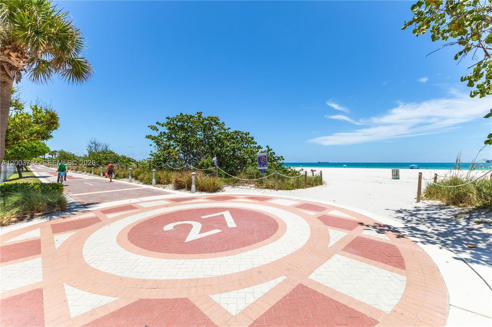 A paved path with a circular "27" marker leads to a sandy beach and ocean — 2655 Collins Ave # 2406, Miami Beach FL 33140, MIAMI BEACH, FL