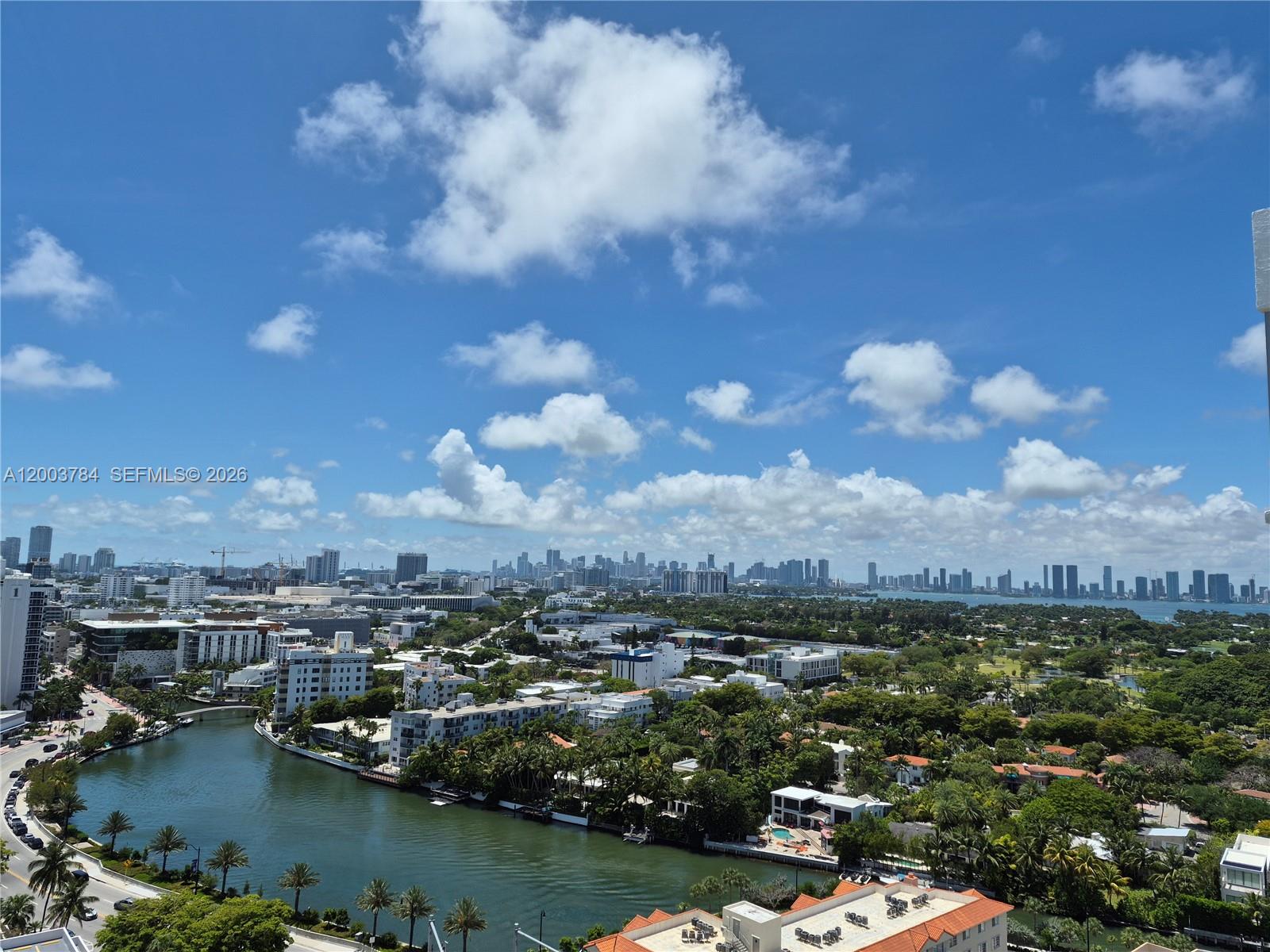 An elevated view shows a canal winding through a city with distant skyscrapers under clouds — 2655 Collins Ave # 2406, Miami Beach FL 33140, MIAMI BEACH, FL