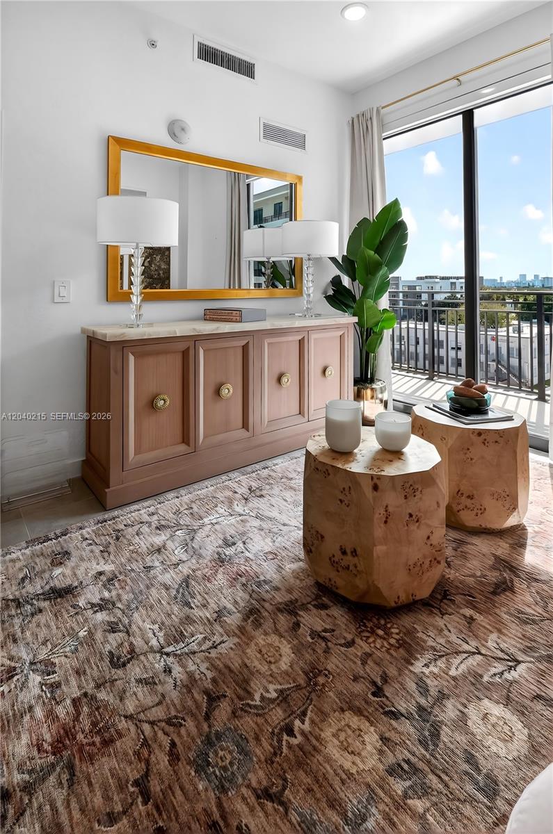 A room features a wooden console table, a large mirror, and two textured wooden side tables — 2001 Van Buren St # 504, Hollywood FL 33020, HOLLYWOOD, FL