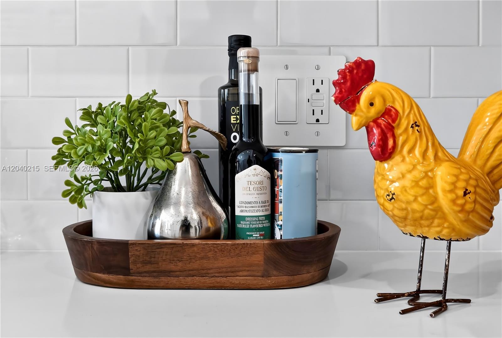 A wooden tray holding a plant, bottles, and a pear sits on a kitchen counter — 2001 Van Buren St # 504, Hollywood FL 33020, HOLLYWOOD, FL