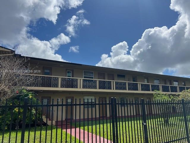 A two-story apartment building with a black metal fence in the foreground — 3901 SW 78th Ct # 219, Miami FL 33155, MIAMI, FL