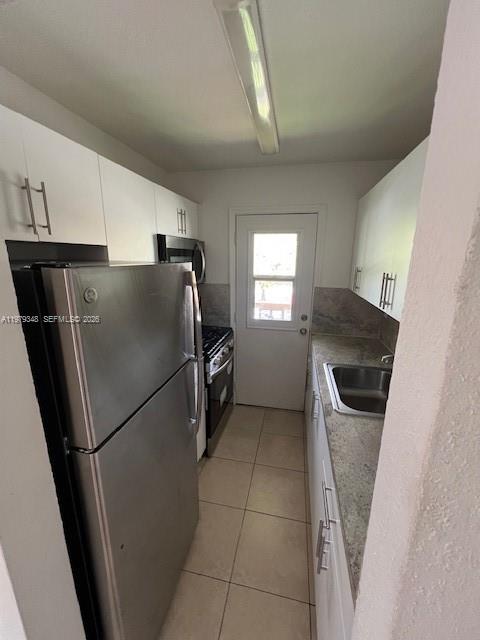 A stainless steel refrigerator stands next to a gas range in a modern kitchen — 3901 SW 78th Ct # 219, Miami FL 33155, MIAMI, FL