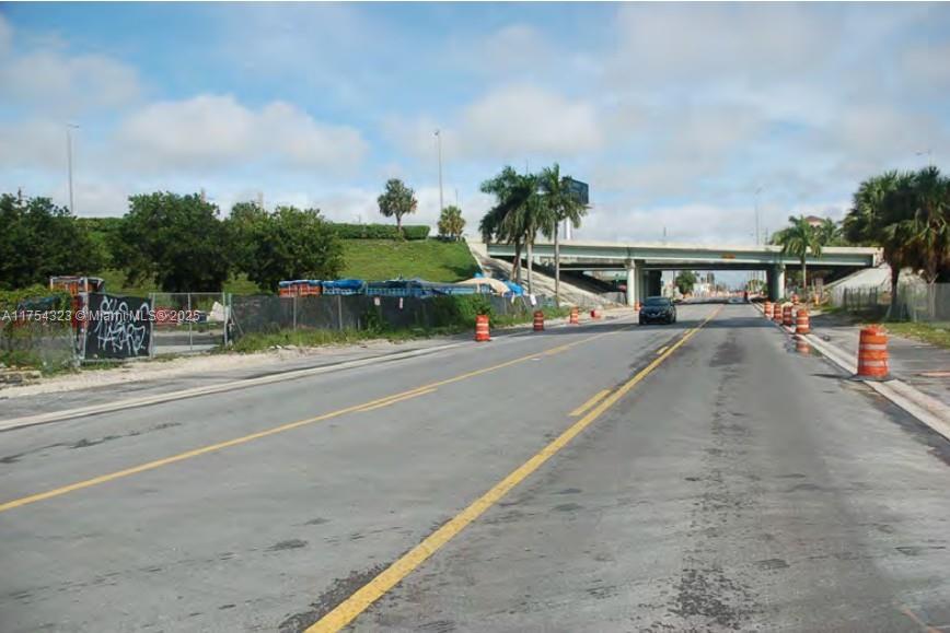 A paved road leads toward an overpass with orange traffic barrels lining the sides — 3632 NW 37 Avenue, Miami FL 33142, MIAMI, FL