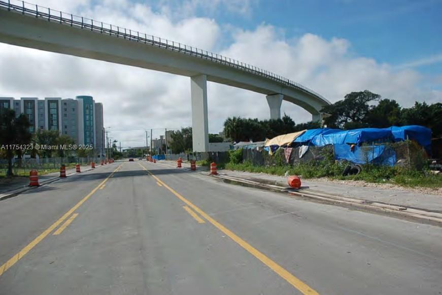 A paved road leads toward a large elevated transit bridge near a construction site — 3632 NW 37 Avenue, Miami FL 33142, MIAMI, FL