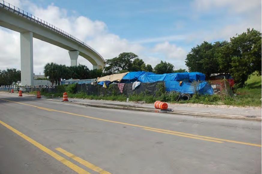 A paved road runs alongside a fenced lot covered with blue tarps near an overpass — 3632 NW 37 Avenue, Miami FL 33142, MIAMI, FL