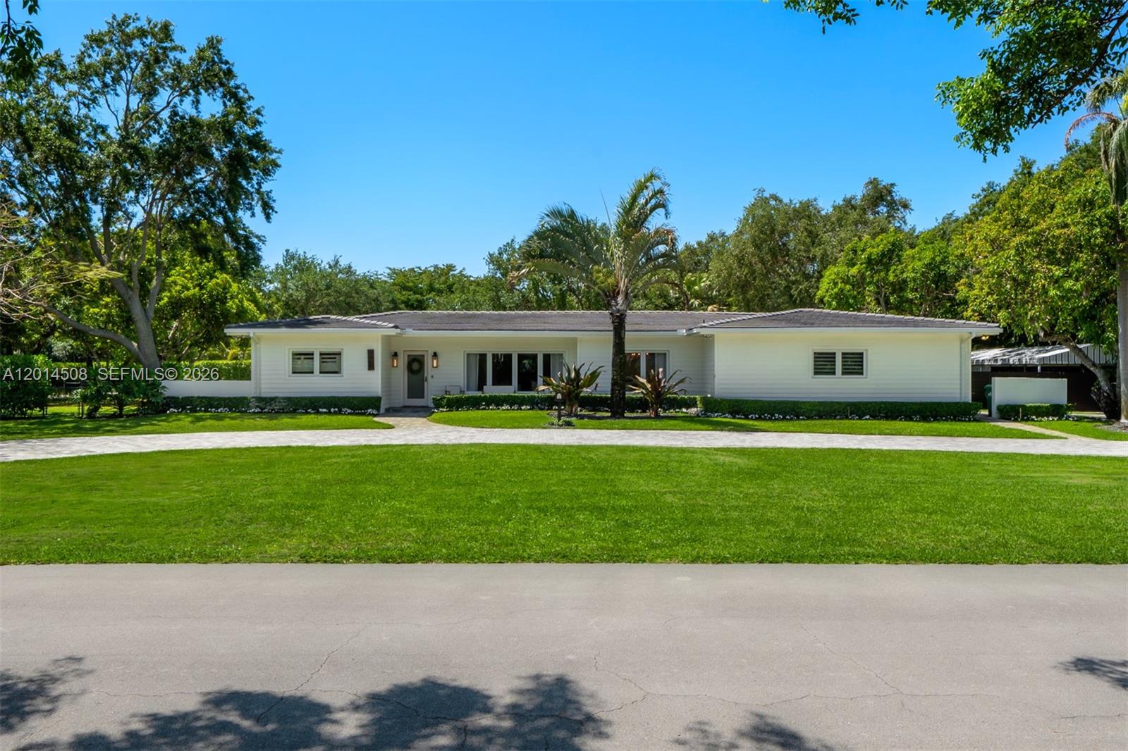 A single-story white house with a paved driveway and a large front lawn — 6450 SW 128th St, Pinecrest FL 33156, PINECREST, FL