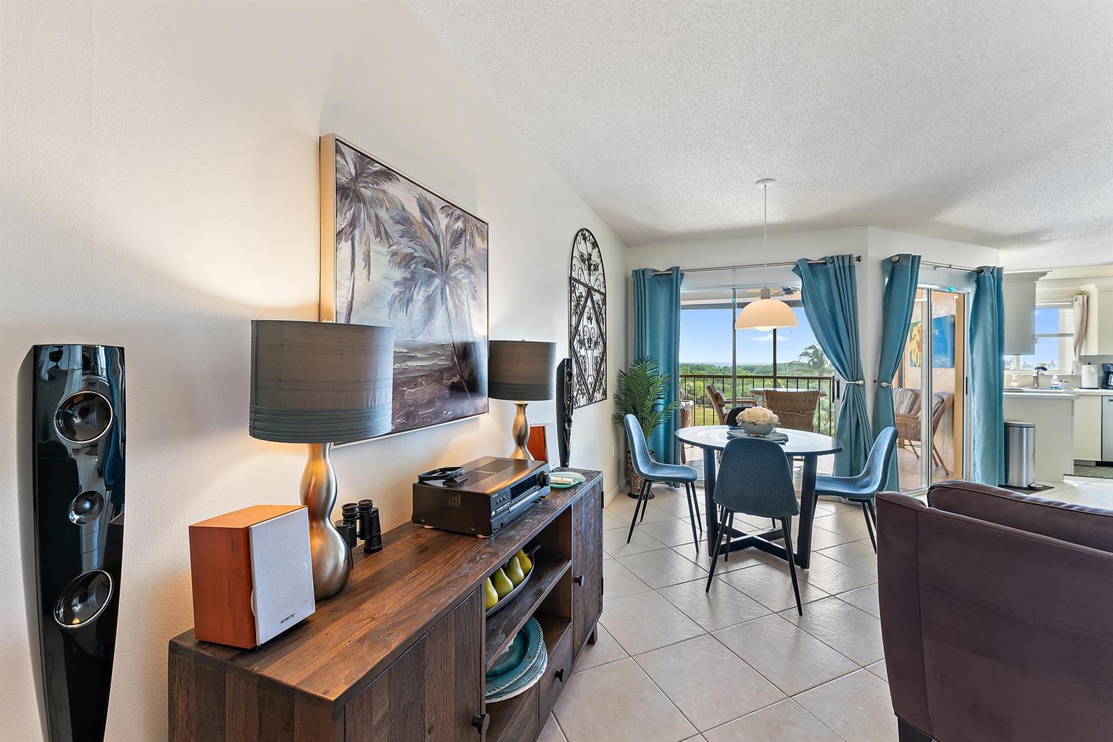 A living and dining area features a wooden console, blue chairs, and a balcony view — 275 Palm Avenue # C503, Jupiter FL 33477, JUPITER, FL
