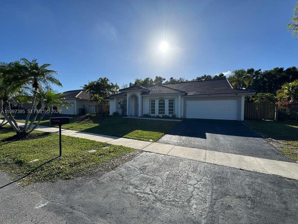 A single-story house with a white exterior, a tiled roof, and a two-car garage — 427 SW 169th Ter, Weston FL 33326, WESTON, FL