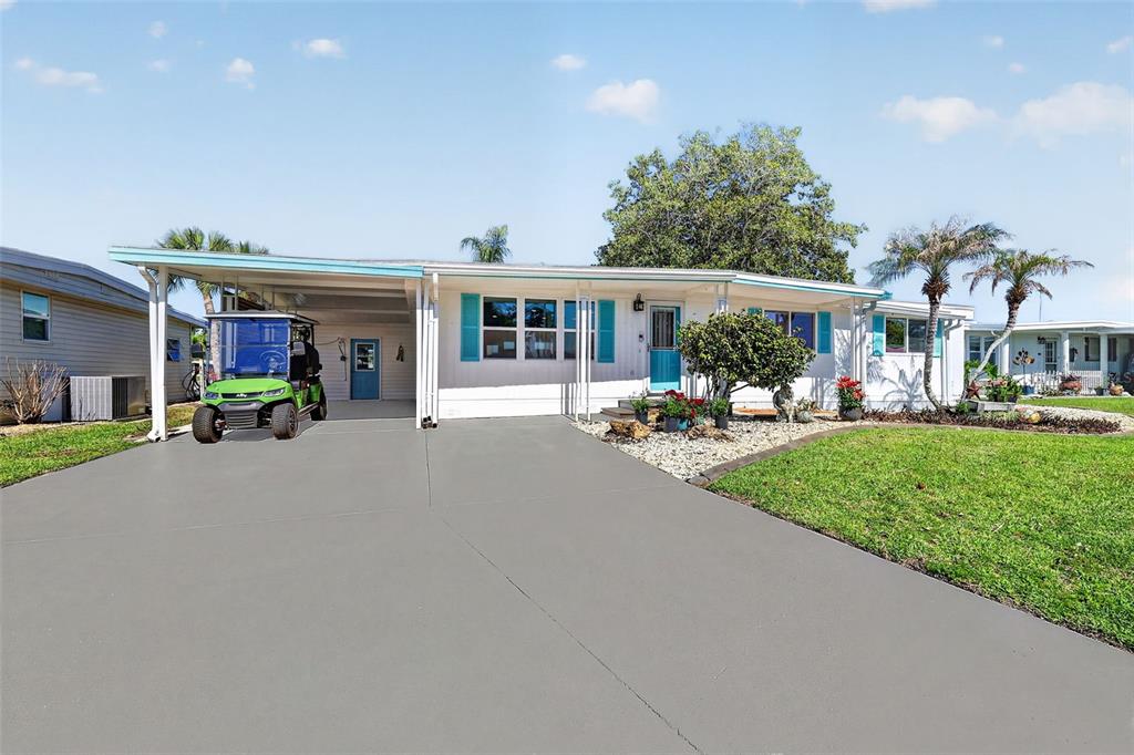 A single-story house with a carport, a green golf cart, and a paved driveway — 1015 SOUTHLAND DRIVE, TAVARES, FL