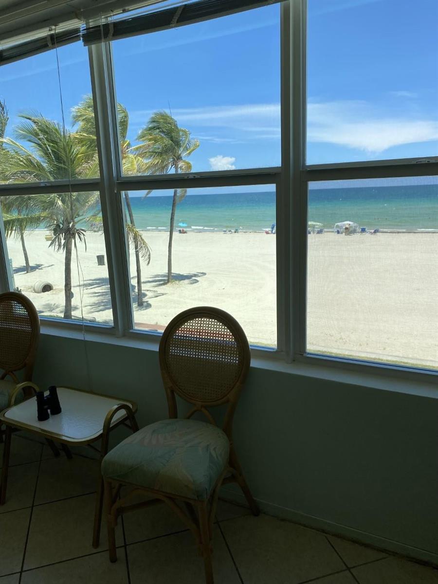 A view of a sandy beach and ocean seen through large windows from a room — 1801 S Surf Road # 2C, Hollywood FL 33019, HOLLYWOOD, FL