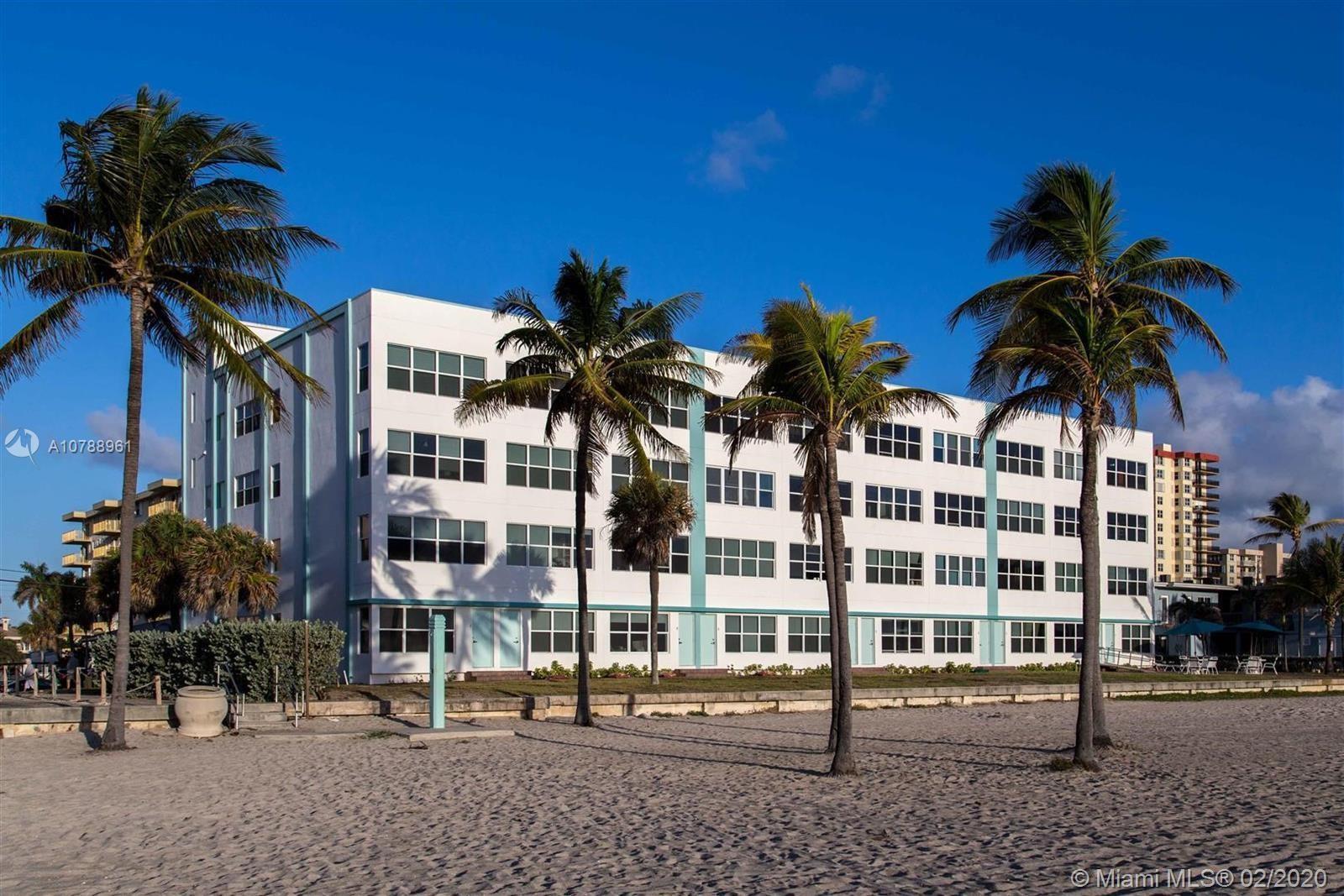 A multi-story white apartment building stands on a sandy beach with several palm trees — 1801 S Surf Road # 2C, Hollywood FL 33019, HOLLYWOOD, FL