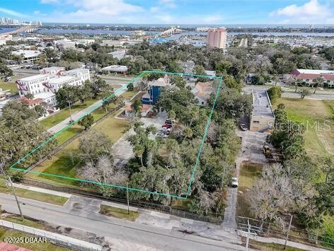An aerial view shows a large, tree-filled lot outlined in green with several buildings — 404 S RIDGEWOOD AVENUE, DAYTONA BEACH, FL