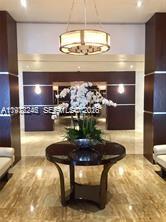 A modern lobby features a round table with a white orchid arrangement under a chandelier — 2451 Brickell Ave # 4P, Miami FL 33129, MIAMI, FL