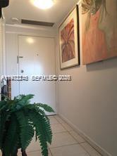 A white door stands at the end of a hallway with tiled floors and artwork — 2451 Brickell Ave # 4P, Miami FL 33129, MIAMI, FL