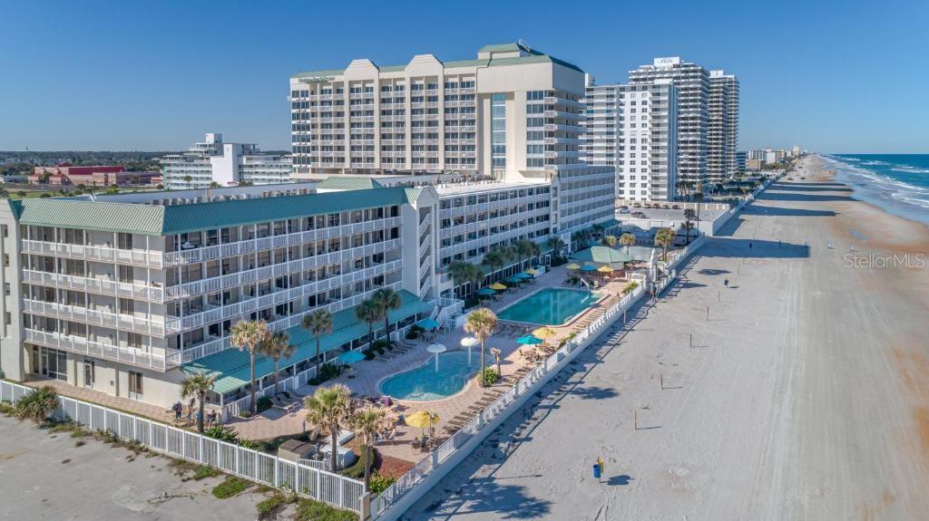 An aerial view shows a large beachfront hotel complex with two swimming pools and balconies — 2700 N ATLANTIC AVENUE UNIT 1201, DAYTONA BEACH, FL