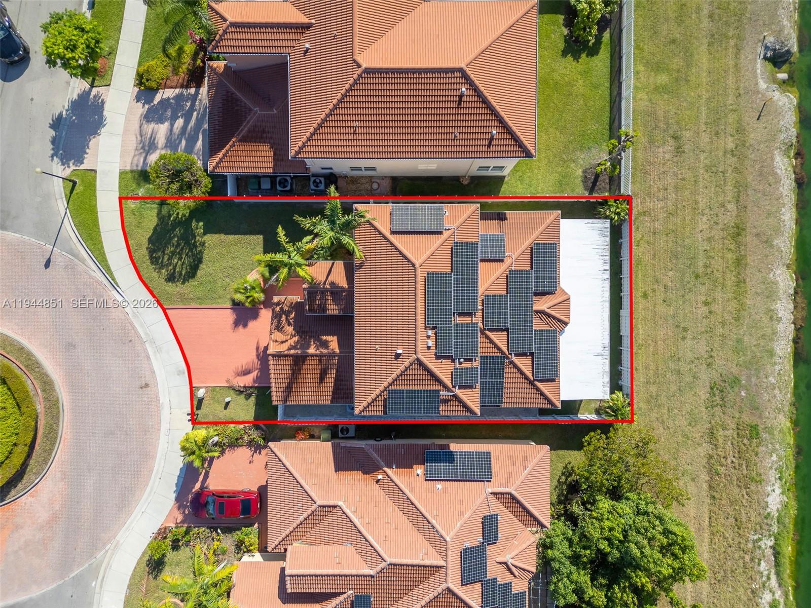 An aerial view shows a house with solar panels on its roof and a backyard — 1856 NE 3rd Ct, Homestead FL 33033, HOMESTEAD, FL